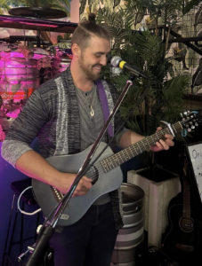 guitar ninja lessons teacher rory price on stage - acoustic